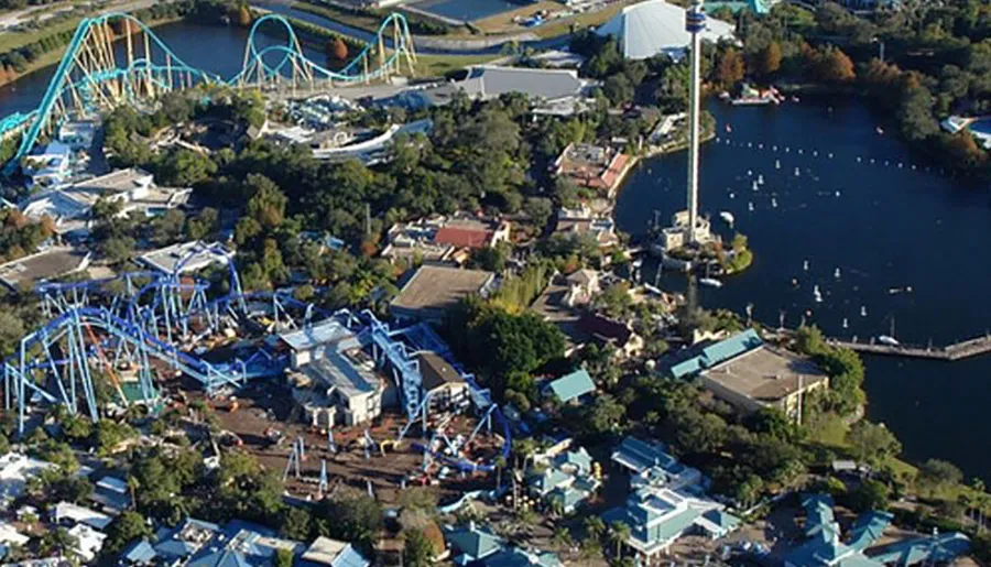 An aerial view of a theme park with roller coasters and a central lake.