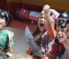 A group of children dressed as pirates and sporting eye patches and bandanas are joyfully engaging in a themed activity with one girl triumphantly raising her fist and holding a toy sword