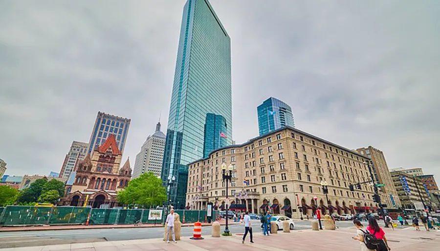 This image showcases a bustling city street scene with a mix of modern and historic architecture under an overcast sky.