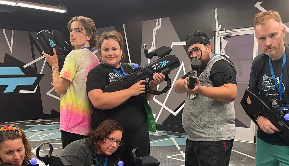 A group of people pose with futuristic laser tag equipment in a game arena