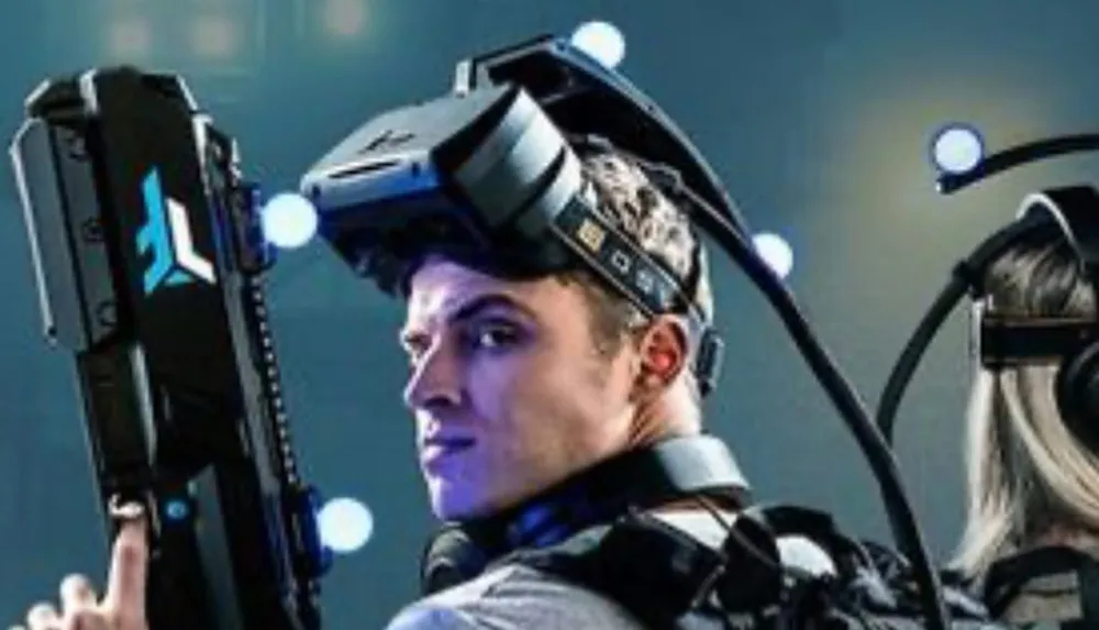 A person is wearing a sophisticated virtual reality VR headset with motion tracking markers apparently engaged in an immersive experience