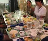 A group of people is enjoying a meal together at a restaurant with various dishes and drinks spread out on the table
