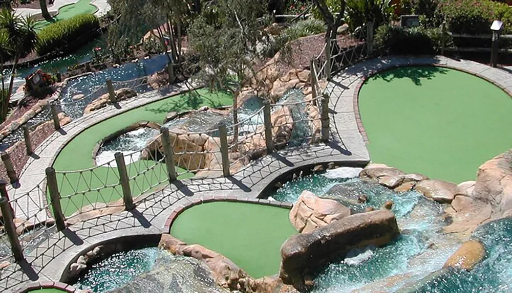 An aerial view of a colorful miniature golf course with various obstacles bridges and water features