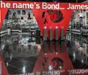The image shows an exhibition space filled with James Bond memorabilia including a car movie posters and other themed displays with a large quote saying The names Bond James Bond prominently featured
