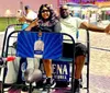 A smiling couple is enjoying a ride on a pedicab adorned with a tequila advertisement in an outdoor setting during the evening