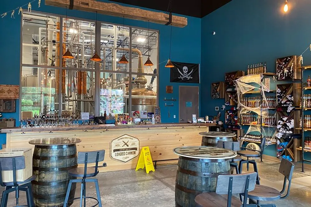 The image shows a spacious distillery tasting room with a distinctive pirate theme copper distillation equipment visible through a large glass partition and various merchandise on display