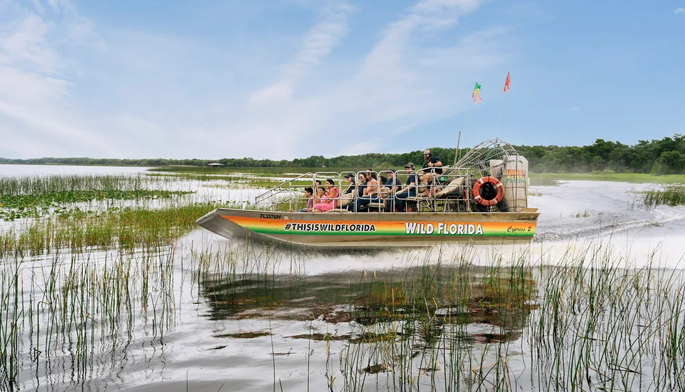 An airboat full of passengers glides through a marshy wetland area showcasing a popular tourist activity in Florida