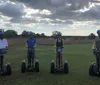 A group of people are enjoying a Segway tour on a forest trail with a smiling woman in the foreground taking a selfie