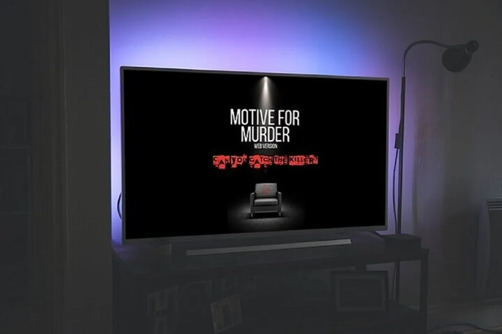 A modern television displaying the title MOTIVE FOR MURDER in a dark room with ambient light from a floor lamp