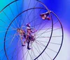 Four performers in blue costumes ride unicycles and hold hands on stage under bright lights part of the Drawn to Life Cirque du Soleil and Disney show