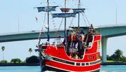 A red and black pirate-themed tour boat named 