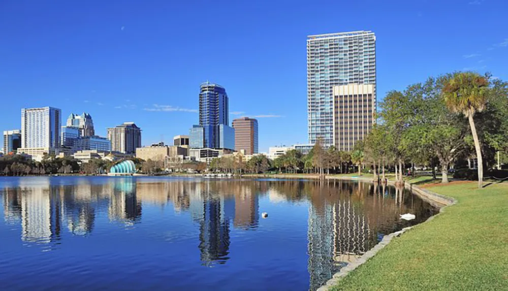 The image features a serene urban park with a calm lake reflecting the surrounding skyscrapers and clear blue sky