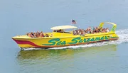 A large group of people are enjoying a ride on a vibrant yellow boat named 