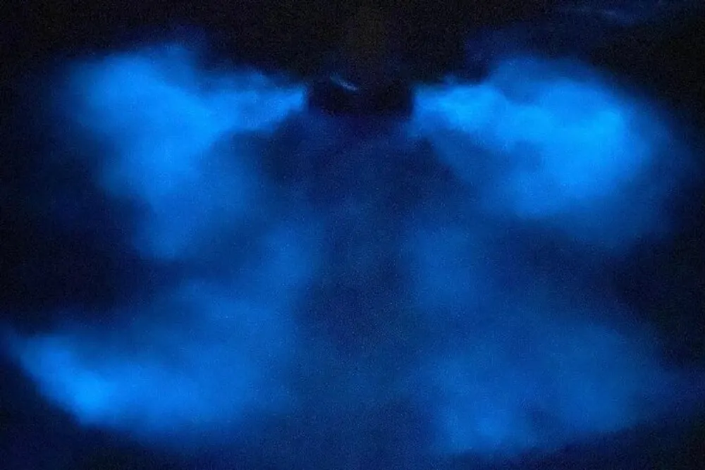 The image appears to show a blue glowing phenomenon that resembles nebulous clouds or an underwater scene with a symmetrical pattern suggesting it might have been manipulated or is reflecting off a surface