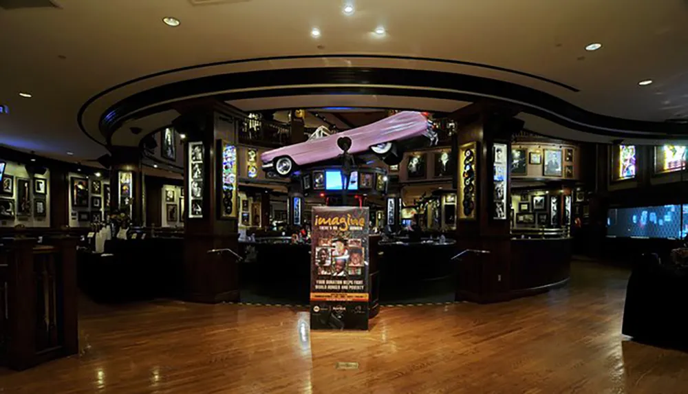The image shows the interior of a dimly-lit restaurant or bar decorated with music memorabilia and a pink car model suspended from the ceiling indicative of a themed establishment likely related to rock or pop culture