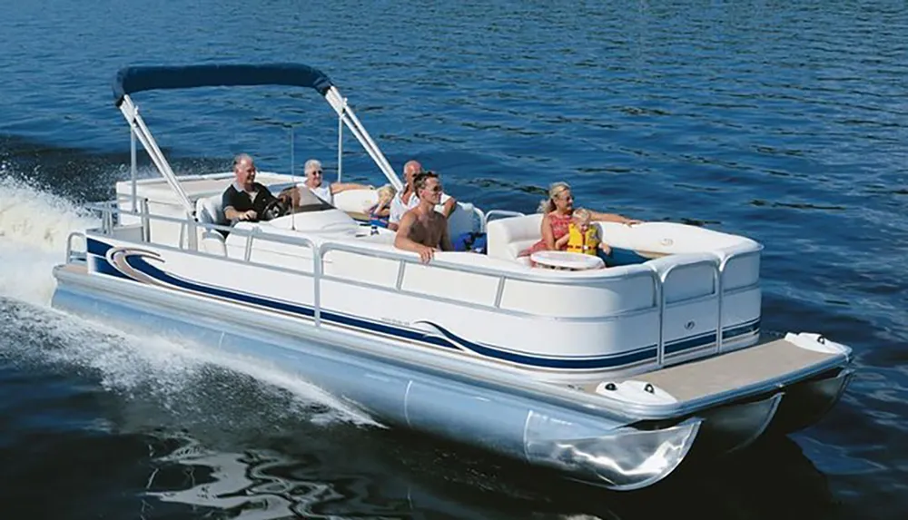 A group of people are enjoying a sunny day on a pontoon boat cruising on a calm body of water