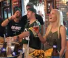 A group of friends are enjoying a lively moment at a sports bar with some dressed in sports team apparel sharing food drinks and laughter