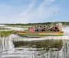 An airboat carrying passengers glides through a marshy landscape with the text THISISWILDFLORIDA painted on its side