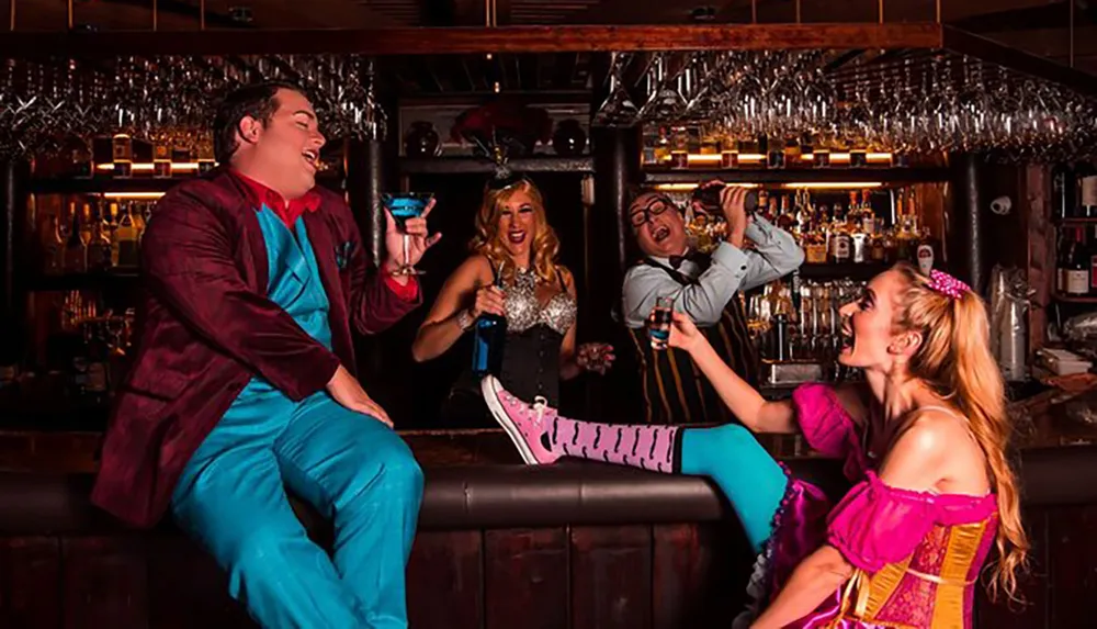 A group of people in colorful and flamboyant costumes are laughing and enjoying themselves at a bar with drinks in hand