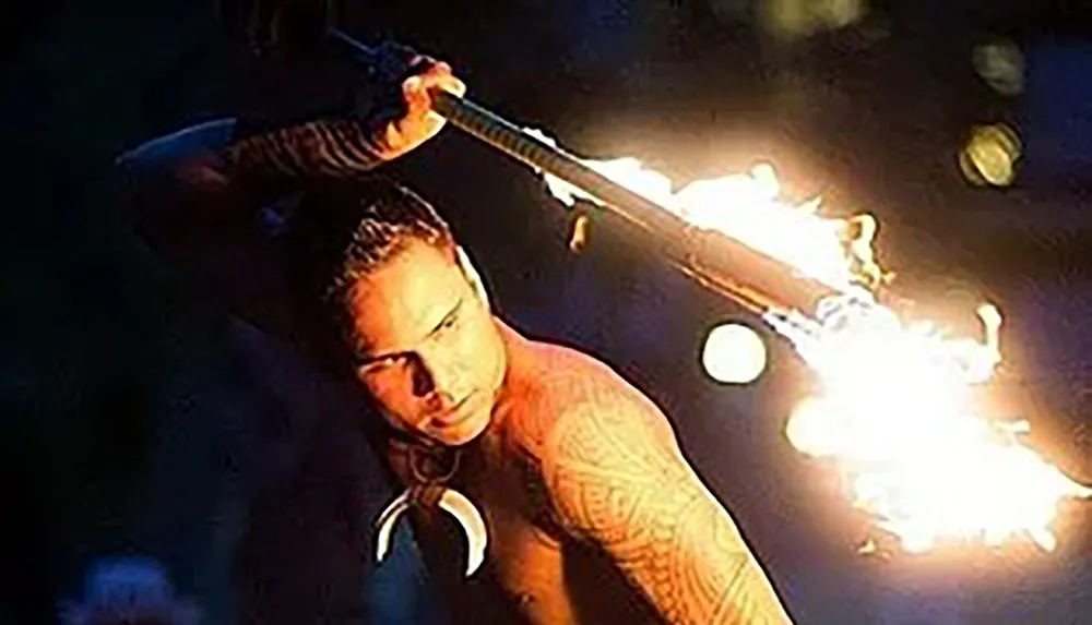 A person is performing a fire breathing act in the dark