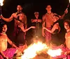 The image shows performers engaging in a fiery dance with insets of a fiery background and a close-up of a dish creating a collage that juxtaposes cultural performance with a culinary item
