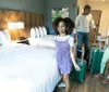 A smiling family with luggage appears to be settling into a modern hotel room
