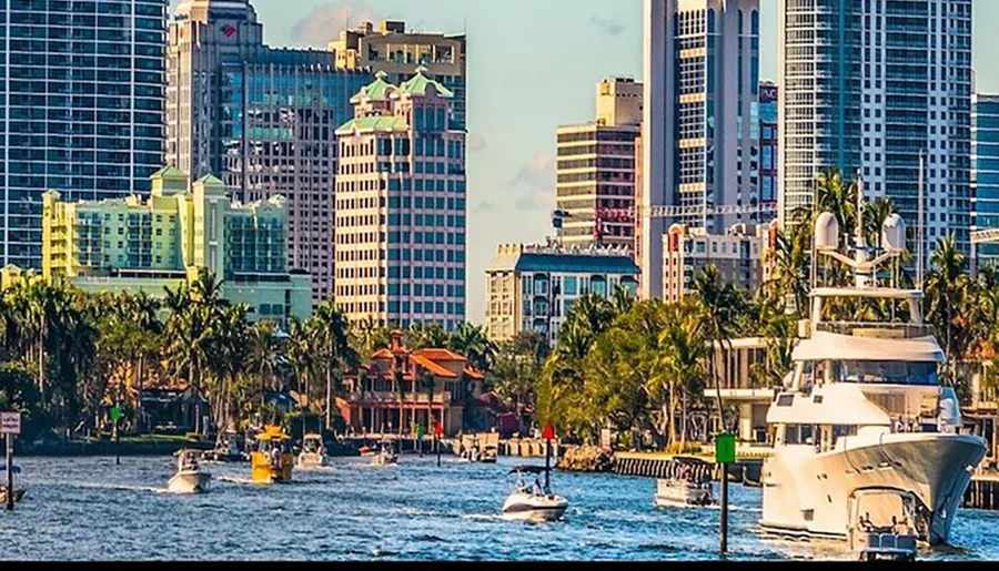 The image showcases a bustling waterfront with multiple boats and a backdrop of modern high-rise buildings interspersed with greenery under a bright blue sky.