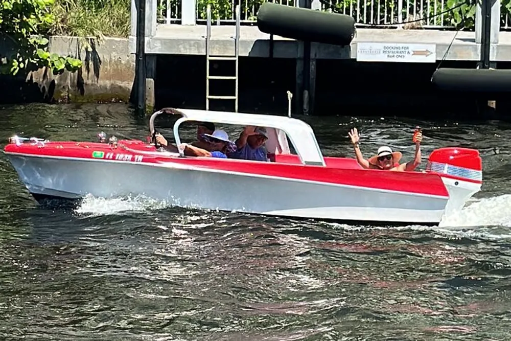 Passengers are enjoying a ride in a red and white speedboat cruising through water