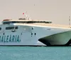 The image shows a large Balearia catamaran ferry named Jaume II on the water near a coastal city