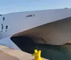 The image shows a large Balearia catamaran ferry named Jaume II on the water near a coastal city