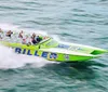 A high-speed powerboat packed with passengers is slicing through the water creating a misty trail behind