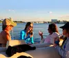 A group of friends is enjoying a boat ride and drinks on a sunny day with a scenic waterfront backdrop