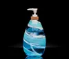 The image shows a beautifully crafted glass sculpture with vibrant blue and red colors resembling a sea creature or flower reflected on a dark surface