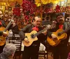 Three mariachi musicians are performing in a festive and decorated restaurant while patrons listen