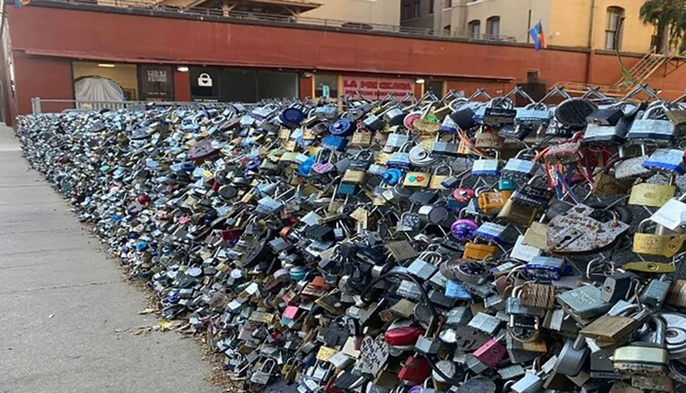 The image shows a dense collection of colorful padlocks attached to a metal railing a common romantic gesture for couples to symbolize their love