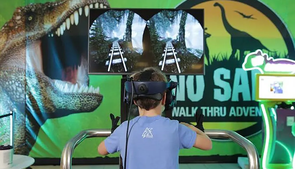 A child is immersed in a virtual reality experience with a dinosaur-themed setup in the background