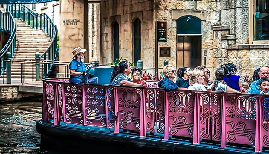 A tour guide is leading a group of passengers on a San Antonio river cruise, with guests listening and observing their surroundings.