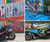 A blue and black three-wheeled vehicle is parked in front of a colorful mural that spells out SAN ANTONIO TEXAS