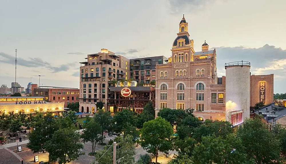 The image shows a vibrant urban district with historical buildings including a structure with a prominently displayed beer brand logo set against an evening sky