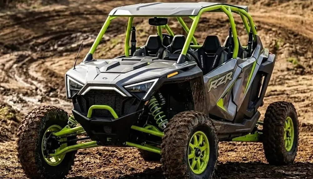 The image shows a gray and neon green off-road utility vehicle UTV with rugged tires on a muddy terrain