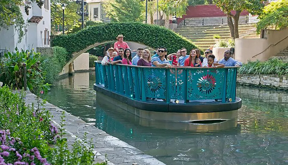 A group of people enjoy a guided boat tour along a scenic urban waterway