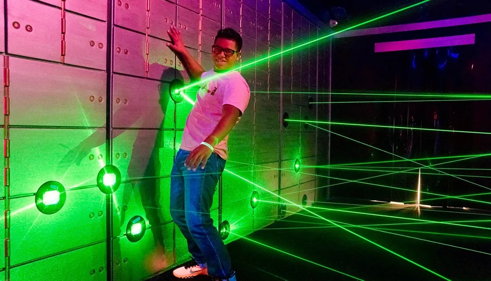 A person is posing with a smile in a room with vibrant green laser lights and a wall with a metallic texture
