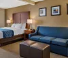 The image shows a neatly arranged hotel room with a large bed crisp linens and modern furnishings creating an inviting atmosphere for guests