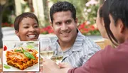 Three people are cheerfully toasting with glasses of white wine outdoors.