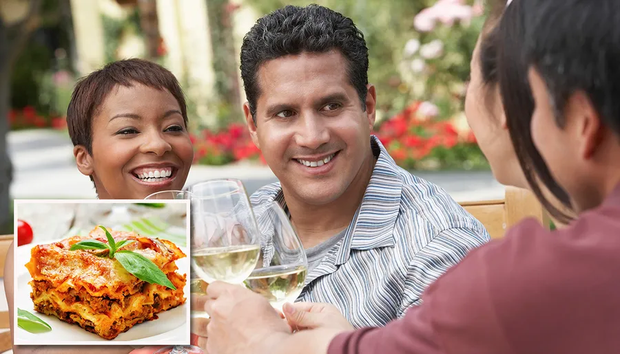 Three people are cheerfully toasting with glasses of white wine outdoors.