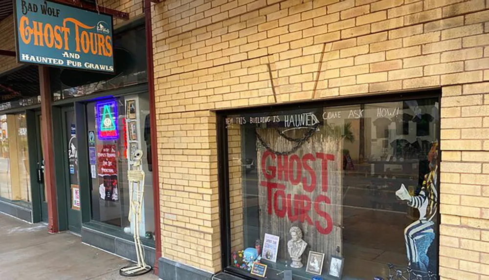 The image shows the exterior of a ghost tour company featuring a sign that reads Bad Wolf Ghost Tours and Haunted Pub Crawls and a window display with the text This building is haunted inviting curiosity and interest in supernatural experiences