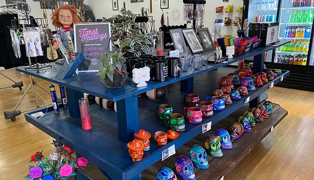 The image shows an eclectic store interior with colorful merchandise including vibrant painted skulls a Chucky doll and a sign offering tarot readings