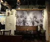 The image shows a rustic restaurant interior with a large wall mural depicting historical figures complemented by antique dcor and hanging old-fashioned lanterns creating a vintage atmosphere