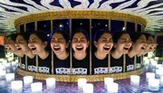 The image shows a laughing girl's reflection repeated multiple times in curved mirrors, creating a circular pattern of identical, joyous expressions.