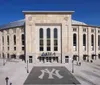 The image displays the exterior of Yankee Stadium with Gate 4 visible and a few people walking nearby